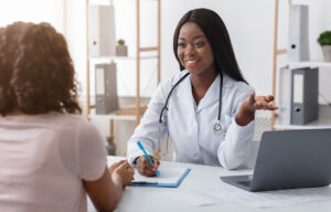Professional dietologist black woman consulting young woman at clinic